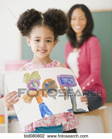 Proud student holding painting in classroom View Large Photo Image Stock Image - Proud student holding painting in classroom. Fotosearch