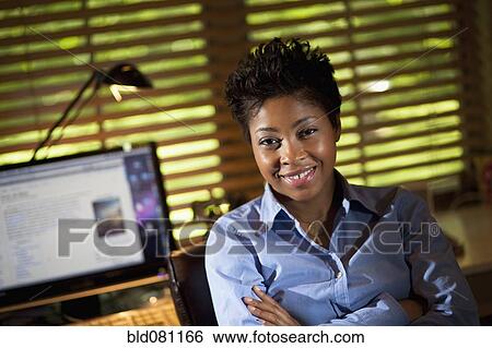 Stock Photograph - Smiling Black businesswoman in office. Fotosearch