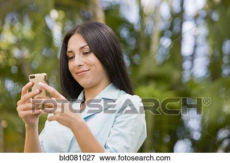 Stock Photo - Turkish woman text messaging on cell phone. Fotosearch