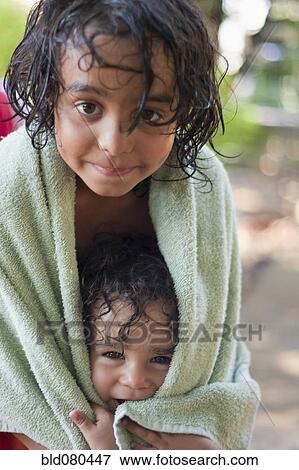 Stock Photo - Wet mixed race boy and brother wrapped in towel. Fotosearch