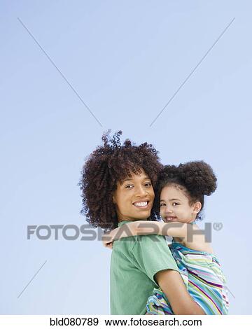 Stock Photo - Woman carrying daughter. Fotosearch