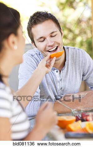 Woman feeding orange to man View Large Photo Image Stock Photograph - Woman feeding orange to man. Fotosearch