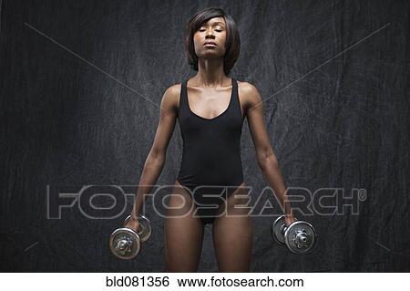 Stock Photograph - Black woman using hand weights. Fotosearch