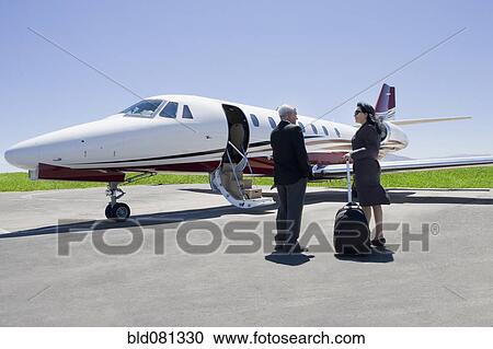 Stock Image - Business people boarding private jet. Fotosearch