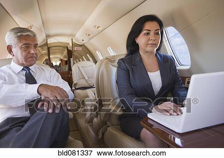 Business people working on private jet View Large Photo Image Stock Photo - Business people working on private jet. Fotosearch