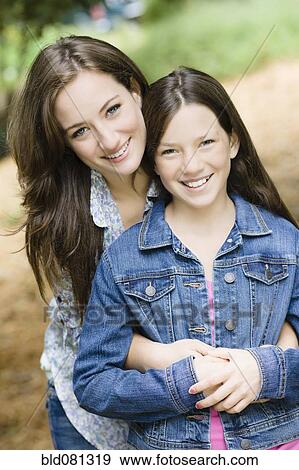 Caucasian mother hugging daughter View Large Photo Image Stock Photo - Caucasian mother hugging daughter. Fotosearch