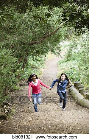 Girls holding hands and running on path View Large Photo Image Stock Image - Girls holding hands and running on path. Fotosearch