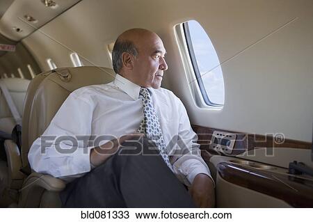 Stock Image - Hispanic businessman on private jet. Fotosearch