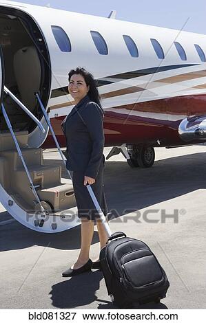 Hispanic businesswoman boarding private jet View Large Photo Image Stock Photo - Hispanic businesswoman boarding private jet. Fotosearch