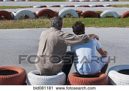 Stock Image - Hispanic grandfather and grandson on go-cart track. Fotosearch