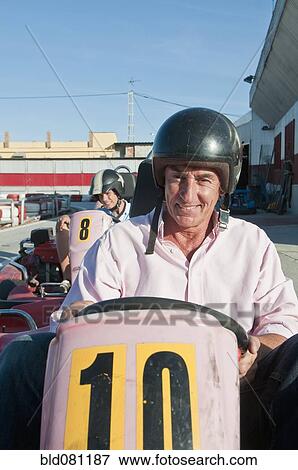 Stock Photo - Hispanic grandfather and grandson on go-cart track. Fotosearch
