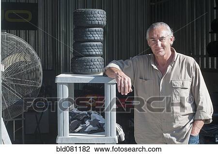 Stock Image - Hispanic mechanic in workshop. Fotosearch