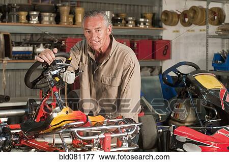 Stock Photo - Hispanic mechanic working on go-cart. Fotosearch