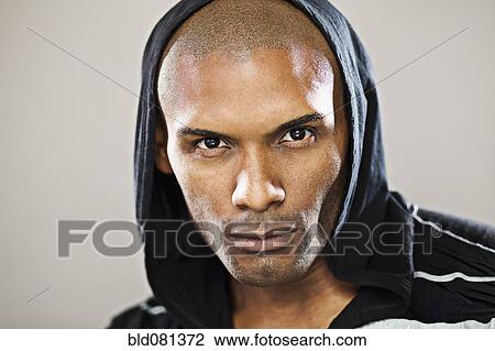 Stock Image - Serious Hispanic man wearing hoody. Fotosearch