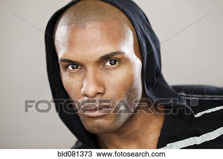 Stock Image - Serious Hispanic man wearing hoody. Fotosearch