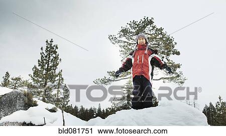 Boy standing in snow with arms outstretched View Large Photo Image Stock Image - Boy standing in snow with arms outstretched. Fotosearch