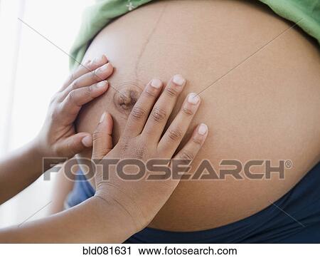 Close up of Black boy touching pregnant mother's stomach View Large Photo Image Stock Image - Close up of Black boy touching pregnant mother's stomach. Fotosearch
