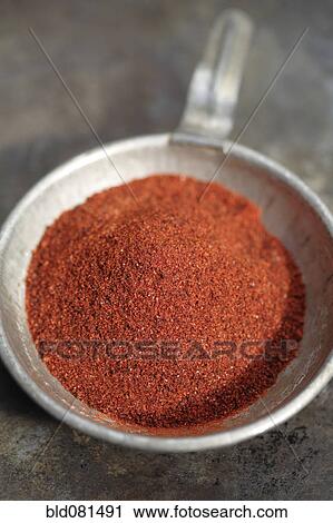Stock Image - Close up of chili powder in measuring spoon. Fotosearch