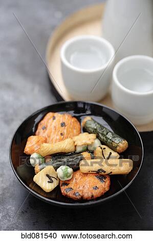 Stock Image - Close up of Japanese rice crackers and sake. Fotosearch