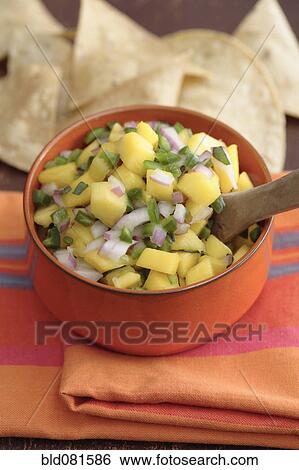 Stock Photograph - Close up of mango salsa and tortilla chips. Fotosearch