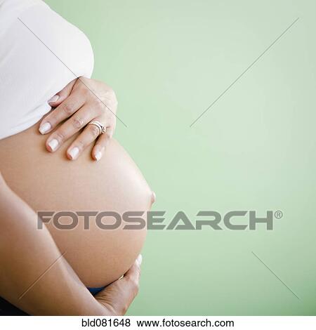 Stock Photo - Close up of pregnant Black woman's stomach. Fotosearch