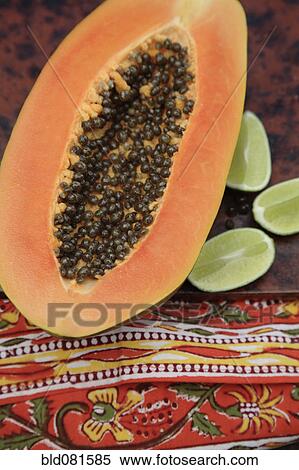 Stock Photography - Close up of split papaya and limes. Fotosearch