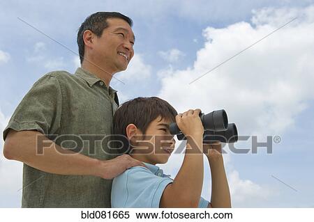 Stock Photography - Father with son looking through binoculars. Fotosearch
