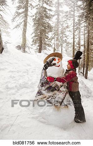Stock Photograph - Girl hugging snowman. Fotosearch