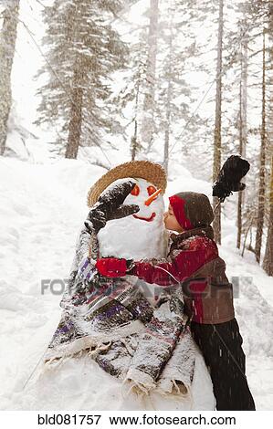Stock Photo - Girl kissing snowman. Fotosearch