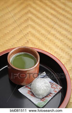 Stock Image - Japanese green Matcha tea and mochi sweet on tray. Fotosearch