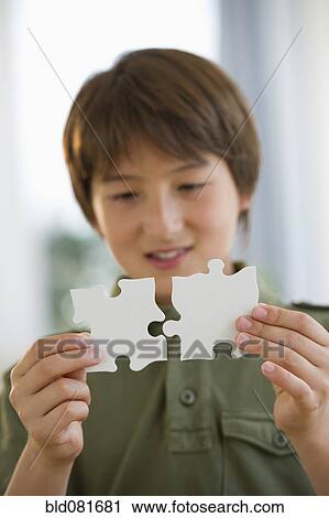 Mixed race boy connecting jigsaw pieces View Large Photo Image Stock Image - Mixed race boy connecting jigsaw pieces. Fotosearch