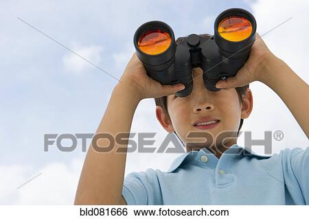 Stock Photograph - Mixed race boy looking through binoculars. Fotosearch