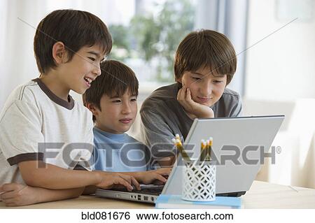 Mixed race brothers using laptop View Large Photo Image Stock Photograph - Mixed race brothers using laptop. Fotosearch