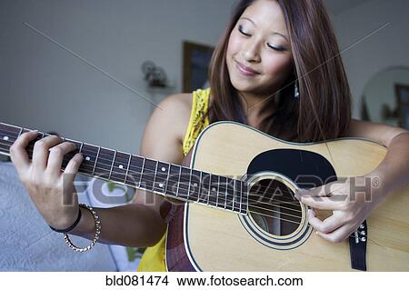 Mixed race teenage girl playing guitar View Large Photo Image Picture - Mixed race teenage girl playing guitar. Fotosearch