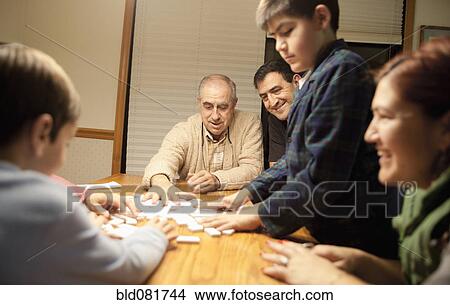 Multi-generation family playing dominoes at table View Large Photo Image Picture - Multi-generation family playing dominoes at table. Fotosearch