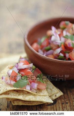 Stock Image - Salsa fresca in bowl and on tortilla chip. Fotosearch