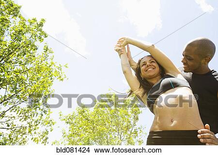 Picture - Smiling couple stretching outdoors. Fotosearch