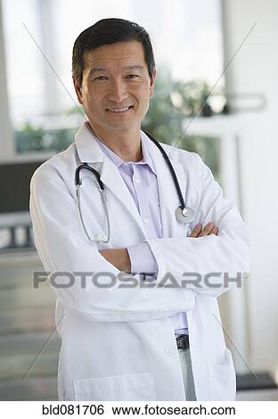 Smiling doctor with arms crossed View Large Photo Image Stock Photograph - Smiling doctor with arms crossed. Fotosearch