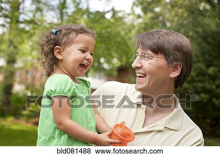 Stock Photo - Smiling father holding daughter. Fotosearch