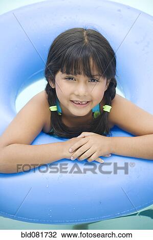 Smiling Hispanic girl with inner tube in swimming pool View Large Photo Image Stock Image - Smiling Hispanic girl with inner tube in swimming pool. Fotosearch