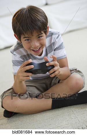 Smiling mixed race boy playing video game View Large Photo Image Picture - Smiling mixed race boy playing video game. Fotosearch