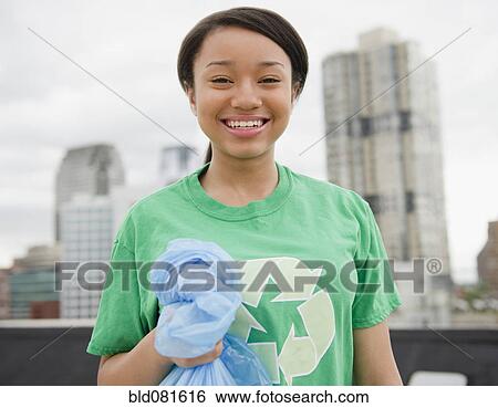 Stock Photograph - Smiling mixed race teenage girl wearing recycling t-shirt. Fotosearch