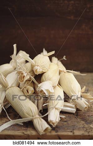 Picture - Stack of wrapped corn tamales. Fotosearch
