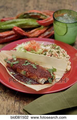 Stock Image - Tamale with red sauce on plate. Fotosearch