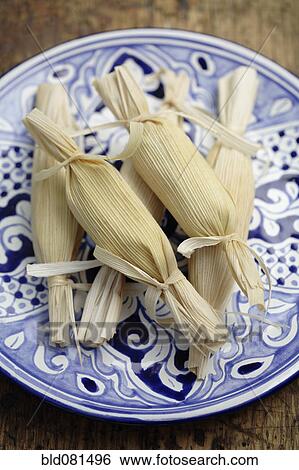 Stock Photograph - Wrapped corn tamales on plate. Fotosearch