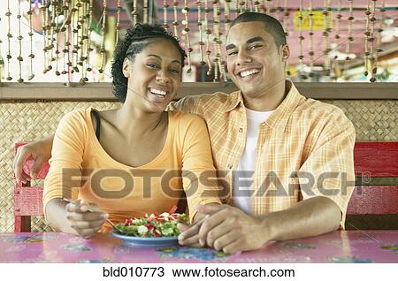 Stock Image - African American couple at table in restaurant. Fotosearch