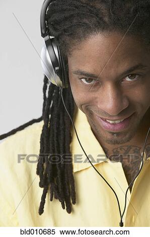 Stock Photography - African American man wearing headphones and smiling. Fotosearch