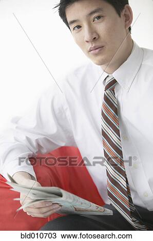Stock Image - Asian businessman with newspaper. Fotosearch