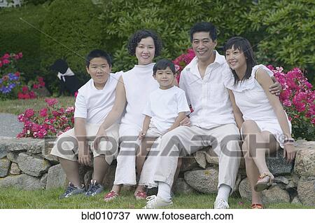 Asian family sitting and smiling outdoors View Large Photo Image Stock Photo - Asian family sitting and smiling outdoors. Fotosearch