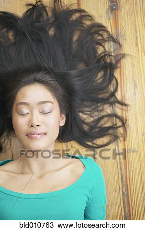 Asian woman laying on floor with hair fanned out View Large Photo Image Stock Image - Asian woman laying on floor with hair fanned out. Fotosearch